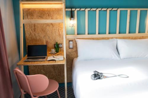 a bedroom with a bed and a desk with a laptop at Birgit Hôtel Le Havre Centre in Le Havre