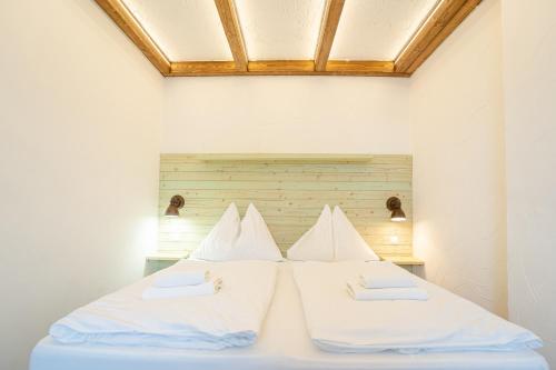 a bed with white sheets and pillows on it at Penzion Maria in Liptovský Mikuláš