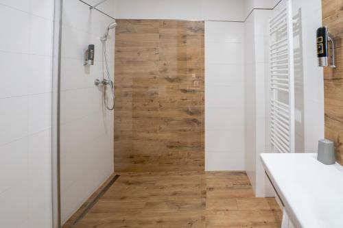 a bathroom with a shower and a wooden wall at Penzion Maria in Liptovský Mikuláš
