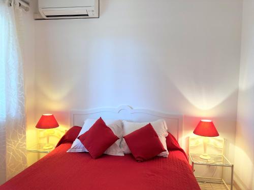 - une chambre avec un lit rouge et deux lampes dans l'établissement Résidence Marie Diane - Laurier des Bois, à Propriano