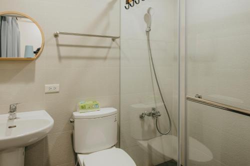 a bathroom with a shower and a toilet and a sink at Wind Wave Ocean Homestay in Toucheng