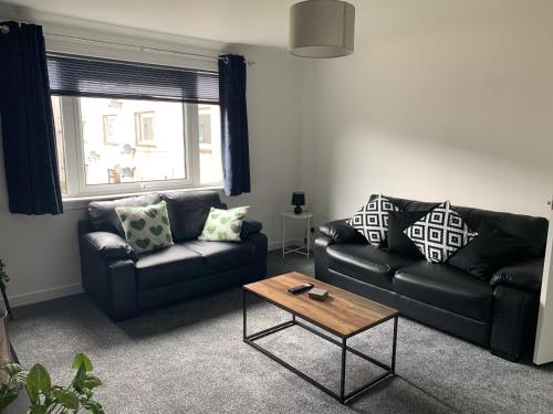 a living room with two couches and a coffee table at Dumfries Apartment in Dumfries