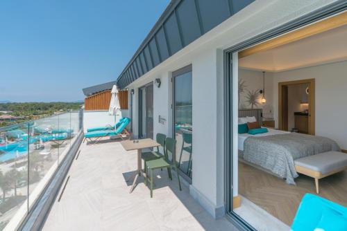 a bedroom with a bed and a balcony with a pool at Liberty Fabay - Ultra All Inclusive in Fethiye