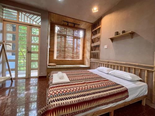a bedroom with a bed in a room with a window at Lan home- Jeep Tour, Motobike tour, rental motobike, private car Cao Bang in Cao Bằng