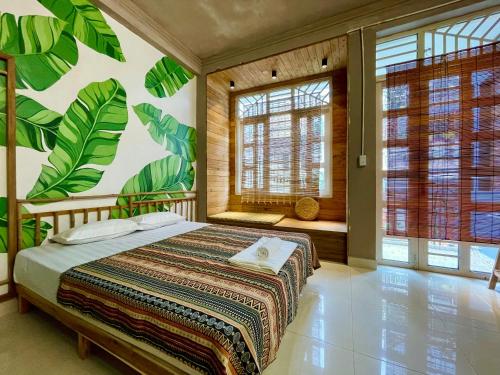 a bedroom with a bed with a mural of leaves at Lan home- Jeep Tour, Motobike tour, rental motobike, private car Cao Bang in Cao Bằng