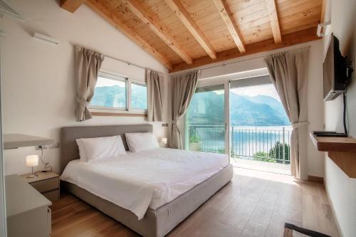 a bedroom with a bed and a large window at Villa Breva - Bellagio in Bellagio