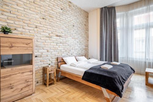 ブダペストにあるCentral Luxury Apartment with ACのレンガの壁、ベッド付きのベッドルーム1室