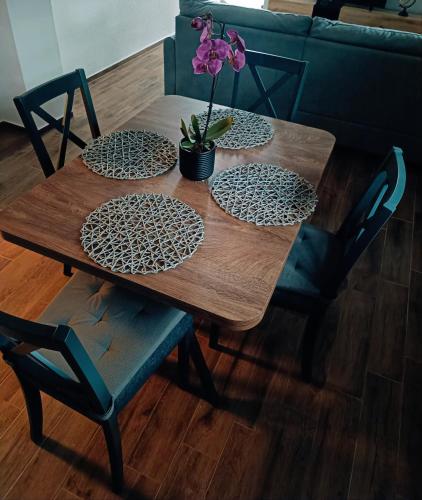 a wooden table with four chairs and a plant on it at Kod Dida in Gospić