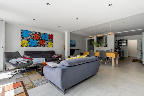 un salon avec un canapé et une salle à manger dans l'établissement Villa tout confort pour 10 - 850 m de la plage, à Les Sables-dʼOlonne