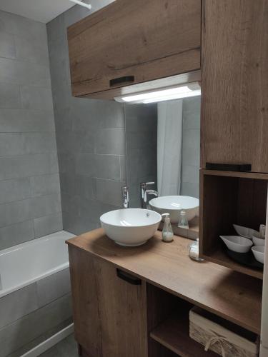 La salle de bains est pourvue d'un lavabo, d'un miroir et d'une baignoire. dans l'établissement Appartement La Toussuire avec vue exceptionnelle, à La Toussuire