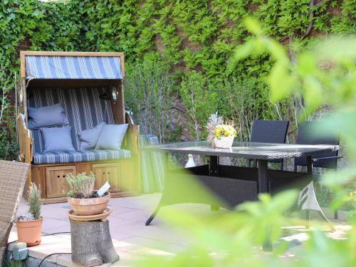 a patio with a table and a chair and a bench at Ferienwohnungen Prihoda in Wilsdruff