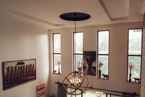 a dining room with windows and a chandelier at Kilihouse Bb Large Ensuite Double Bedroom in Thika