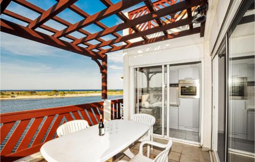 a patio with a white table and chairs on a balcony at Nice Apartment In Saint-Cyprien in Saint-Cyprien