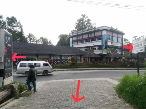 a person walking down a street with a white van at Villa Highland No 8 Berastagi View in Berastagi