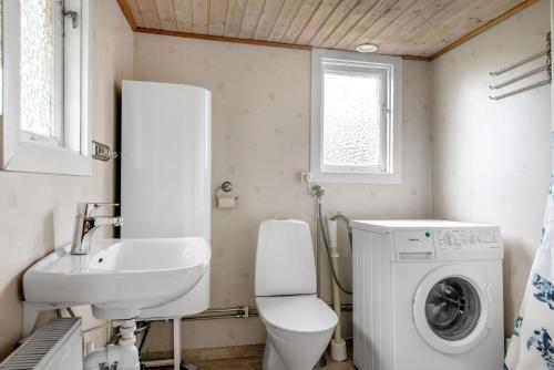 a bathroom with a sink and a washing machine at Nice cottage at Bolmstad Sateri by Lake Bolmen in Bolmsö