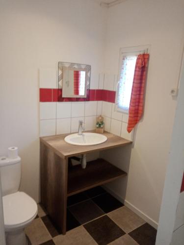 une salle de bain avec un lavabo et des toilettes dans l'établissement L’Oiseau rêveur, à Darbres