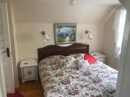 a bedroom with a large bed with a floral bedspread at Villa Verdi in Borgholm