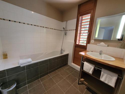 La salle de bains est pourvue d'une baignoire et d'un lavabo. dans l'établissement L'Appartement des Esclargies, à Rocamadour
