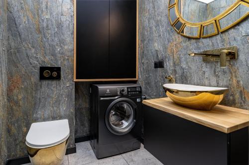 a bathroom with a washing machine and a sink at Villa Warminska in Kręsk