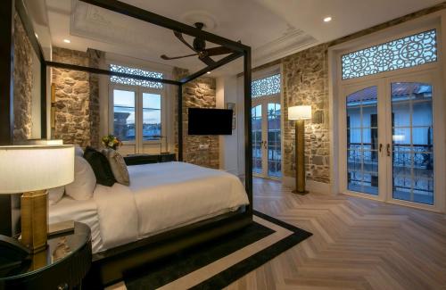 um quarto com uma cama, uma televisão e janelas em Hotel La Compania, In The Unbound Collection By Hyatt na Cidade do Panamá