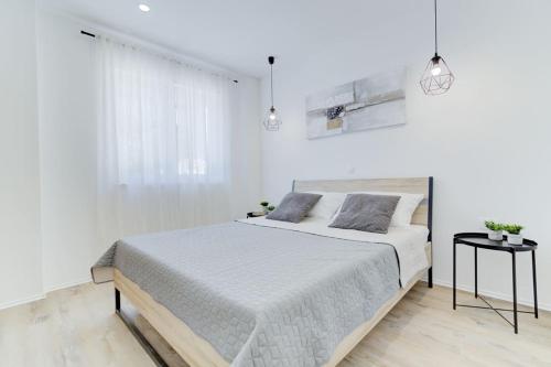 a white bedroom with a large bed and a window at NV Sun 23 by Aneo Travel in Novi Vinodolski
