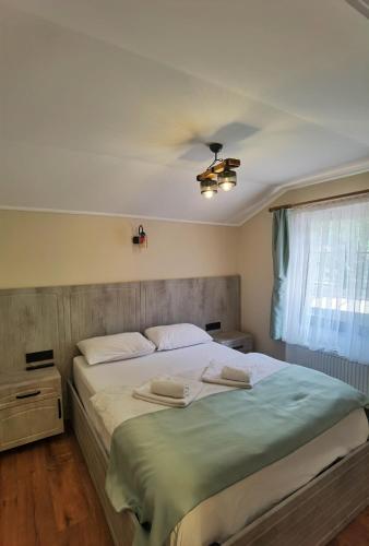 a bedroom with a large bed with a ceiling fan at Kuloğlu Otel ve Restoran in Uzungol