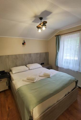 a bedroom with a large bed with a ceiling fan at Kuloğlu Otel ve Restoran in Uzungol