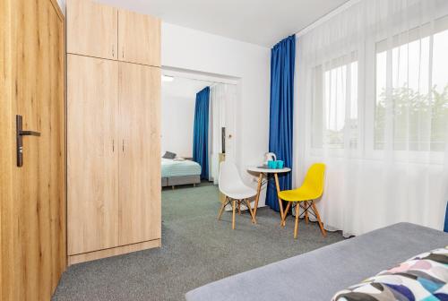 a bedroom with a bed and a table and chairs at Ośrodek Wypoczynkowy CHAMPION in Władysławowo