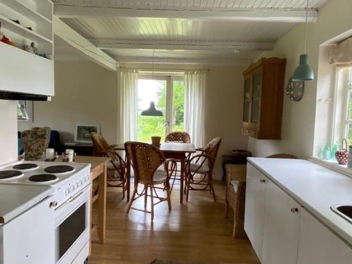 a kitchen and dining room with a table and chairs at Bondehus - Dansk bondehus med patina in Sindal