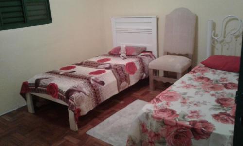 1 dormitorio con 2 camas con colchas rojas y blancas en Casa para temporada, en Serra Negra