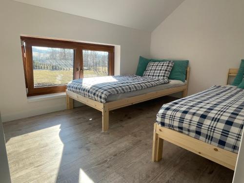 - une chambre avec 2 lits et une fenêtre dans l'établissement Stone House Skalny Domek w Strużnicy, 