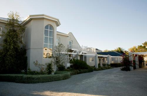 una gran casa blanca con entrada para coches en 11 WESTCLIFF RENTALS, en Hermanus