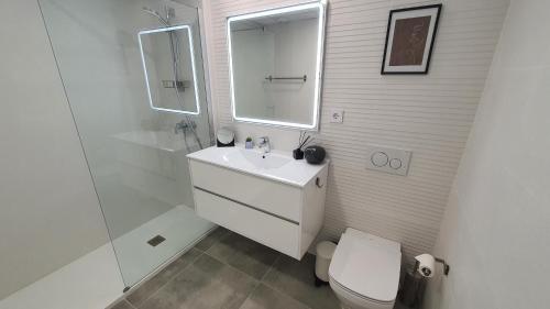 een badkamer met een wastafel, een toilet en een spiegel bij Pool & Snooker Villa in Finestrat
