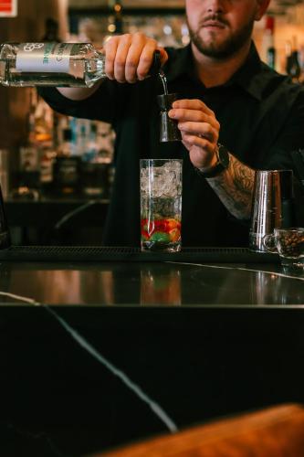 a man is making a drink at a bar at Y Seler in Aberaeron