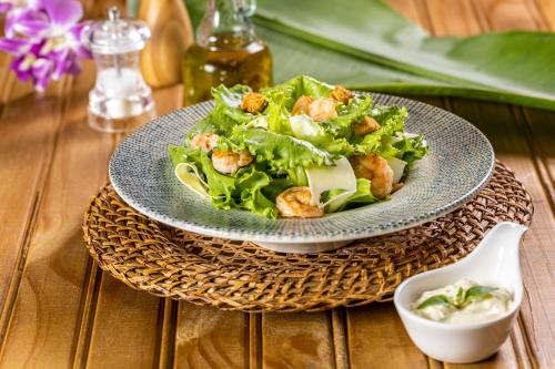 a salad on a blue plate on a table at Praiamar Natal Hotel & Convention in Natal