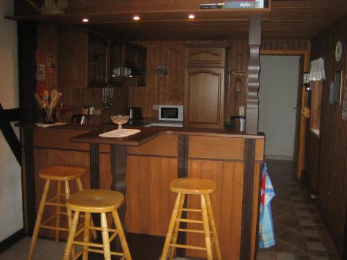 a kitchen with three bar stools and a microwave at Apartment Schlafwandler in Steinigtwolmsdorf