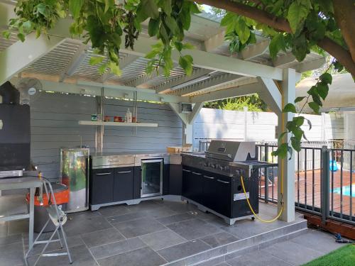 an outdoor kitchen with a stove and a grill at וילה בת גליל יסוד המעלה in Yesod Hamaala