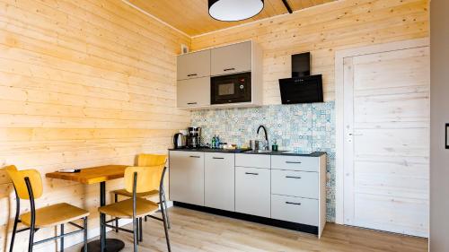 a kitchen with white cabinets and a wooden wall at Stranda in Giżycko