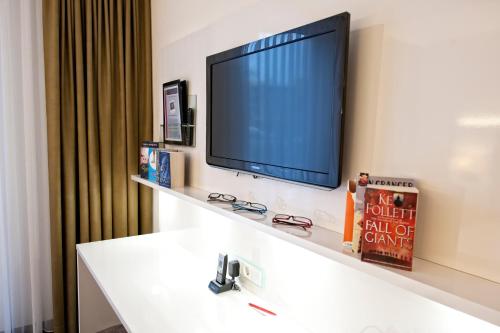 a flat screen tv on a wall in a room at Hotel Jungstil in Darmstadt