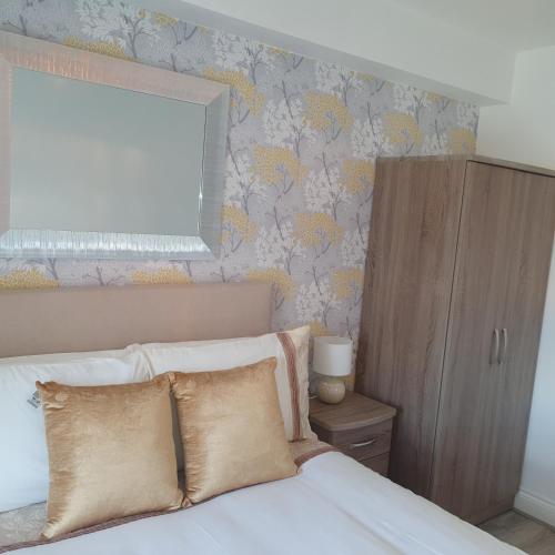 a bedroom with a bed with pillows and a mirror at Arch House B&B & Apartments in Athlone
