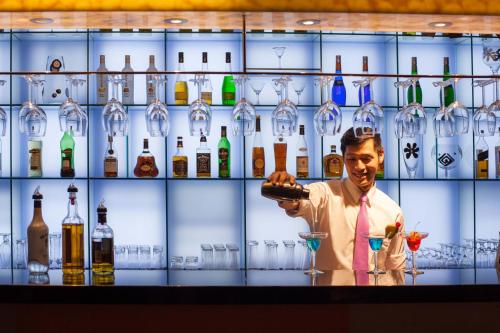 a man pouring a drink in a bar with bottles of alcohol at Park Hotel Hong Kong in Hong Kong