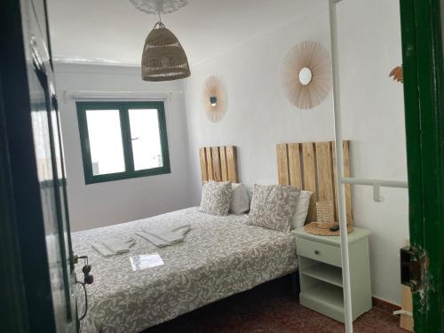 a small bedroom with a bed and a window at Pensión Playa in Puerto de Mogán