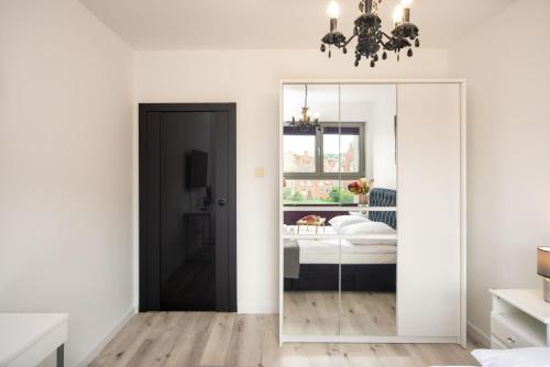 a bedroom with a mirror and a bed at Maya's Flats & Resorts 55 - Pszenna 5 in Gdańsk