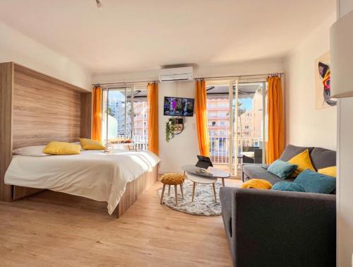 ein Schlafzimmer mit einem Bett und einem Sofa in der Unterkunft Appartement vue mer Parking privé Place Med in Canet-en-Roussillon