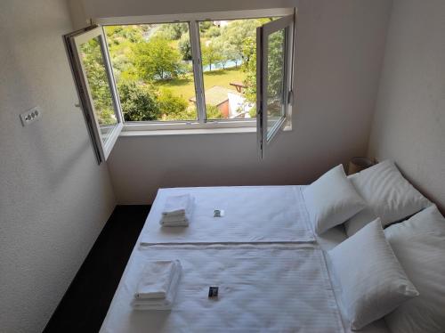 a bed in a small room with a window at Villa The Cave in Blagaj