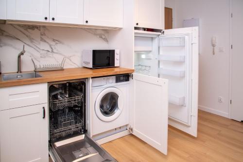 een keuken met een wasmachine en een magnetron bij Maya's Flats & Resorts 38 - Walowa 23C in Gdańsk