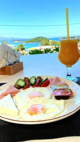 a plate of food on a table with a drink at Hotel Ardiani in Ksamil