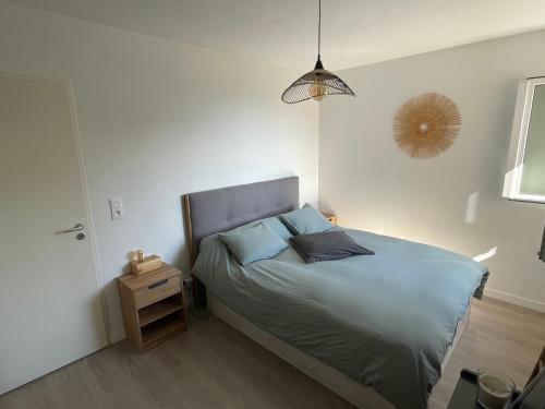 una camera da letto con letto con lenzuola blu e comodino di Charmant T2 proche de la plage et au calme ad Ajaccio