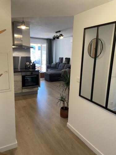 a living room with a couch and a kitchen at Charmant T2 proche de la plage et au calme in Ajaccio