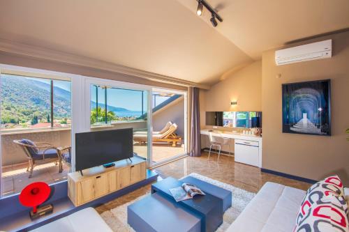 a living room with a desk and a large window at Morina Deluxe Hotel in Oludeniz